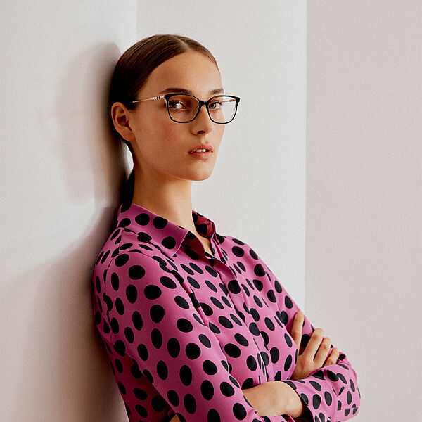 Frau mit pinker Bluse und CAROLINA HERRERA Brille